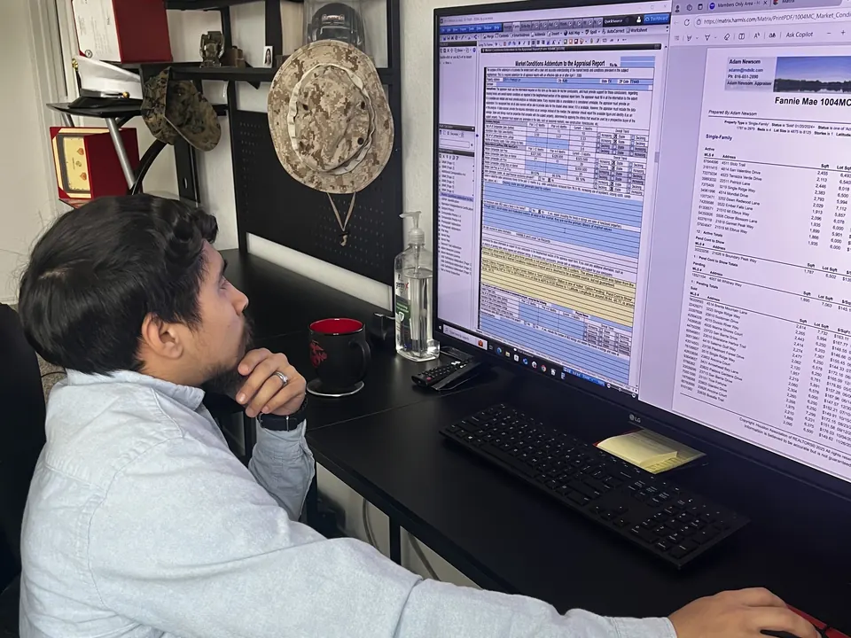 An RSDS appraiser building a market conditions analysis at his desk