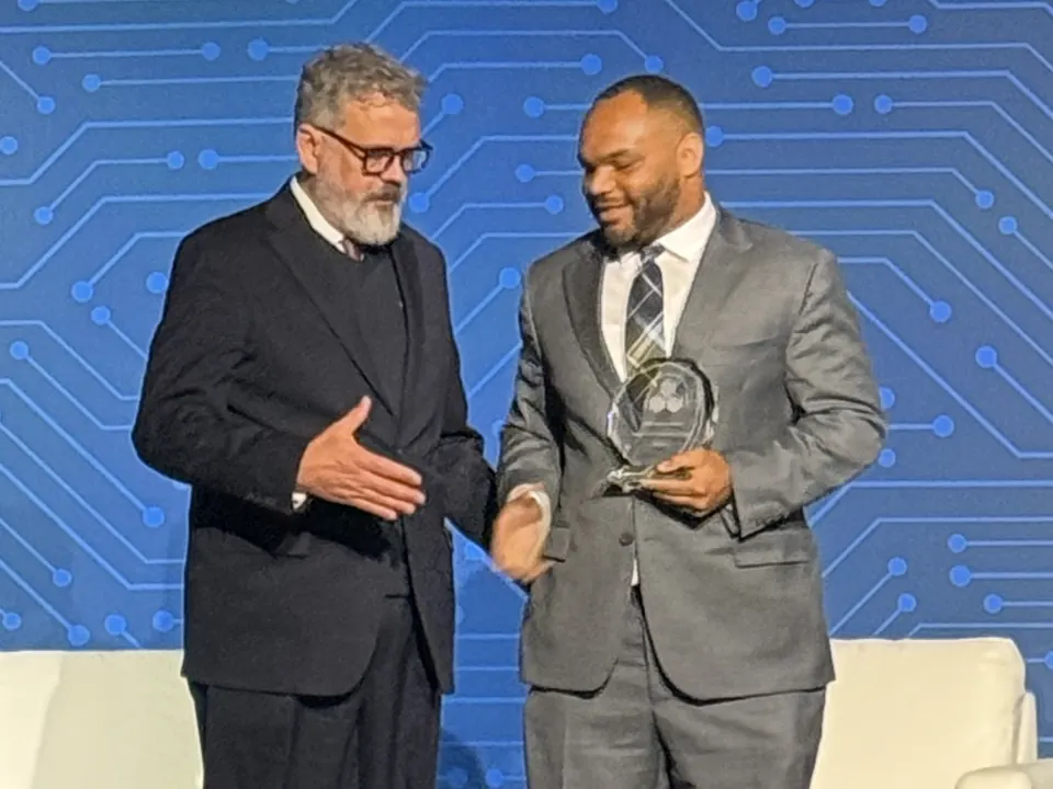 Kharon Brown, Senior Vice President of Operations, accepting an industry award on stage